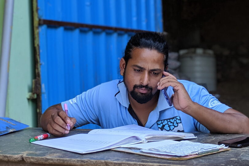 Team member Annu on the phone with paperwork