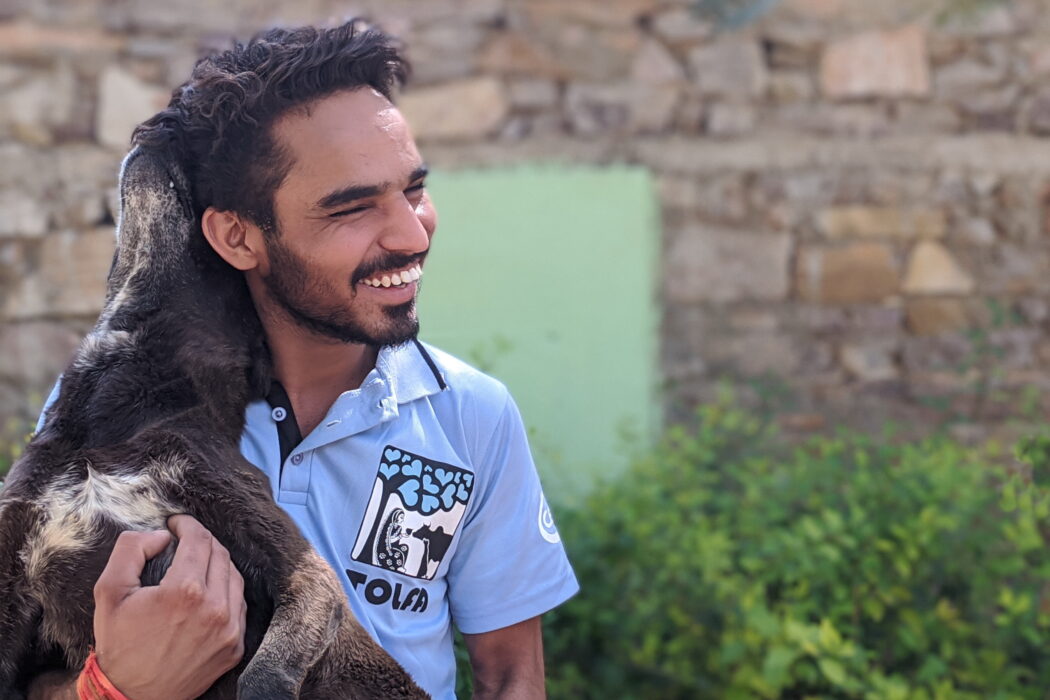 tolfa team member laughing holding a black dog