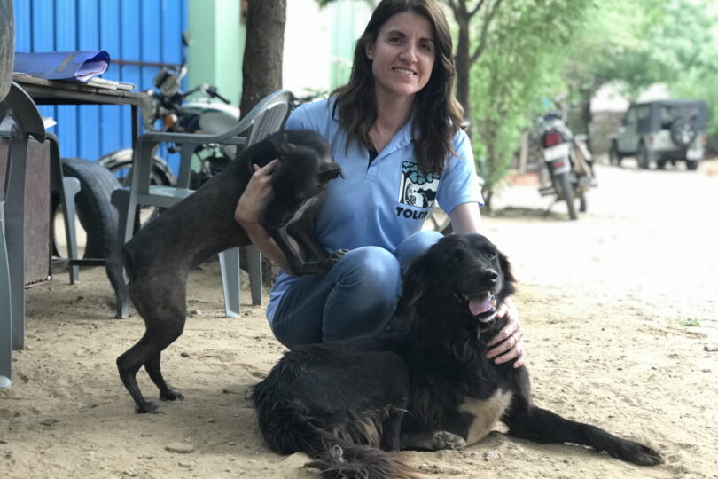 Rachel crouching with Black Bear and another dog at TOLFA